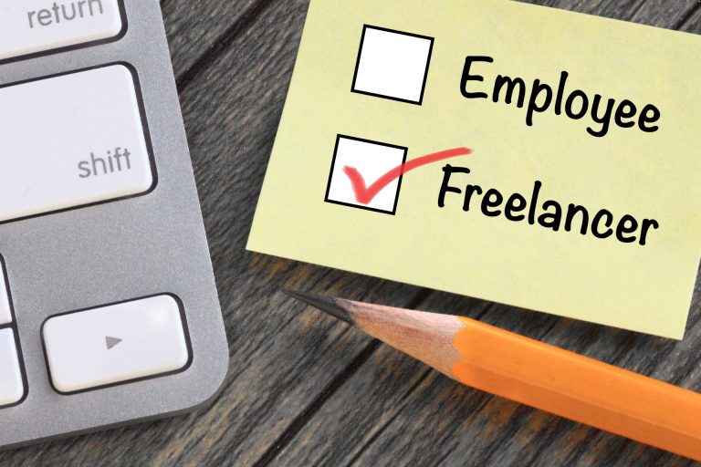 pencil and calculator next to checklist that says employee and freelancer with a checked box next to freelancer